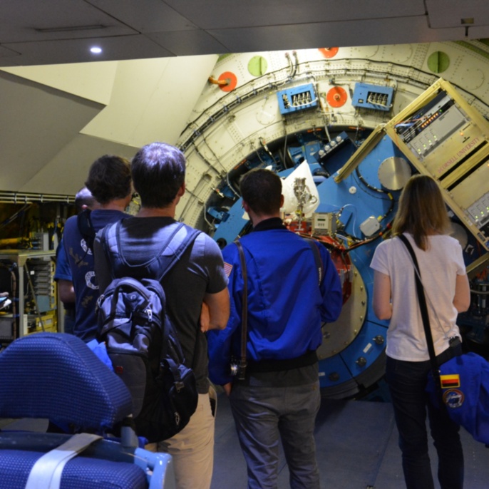 Lehrkräfte stehen beeindruckt vor dem SOFIA-Teleskop